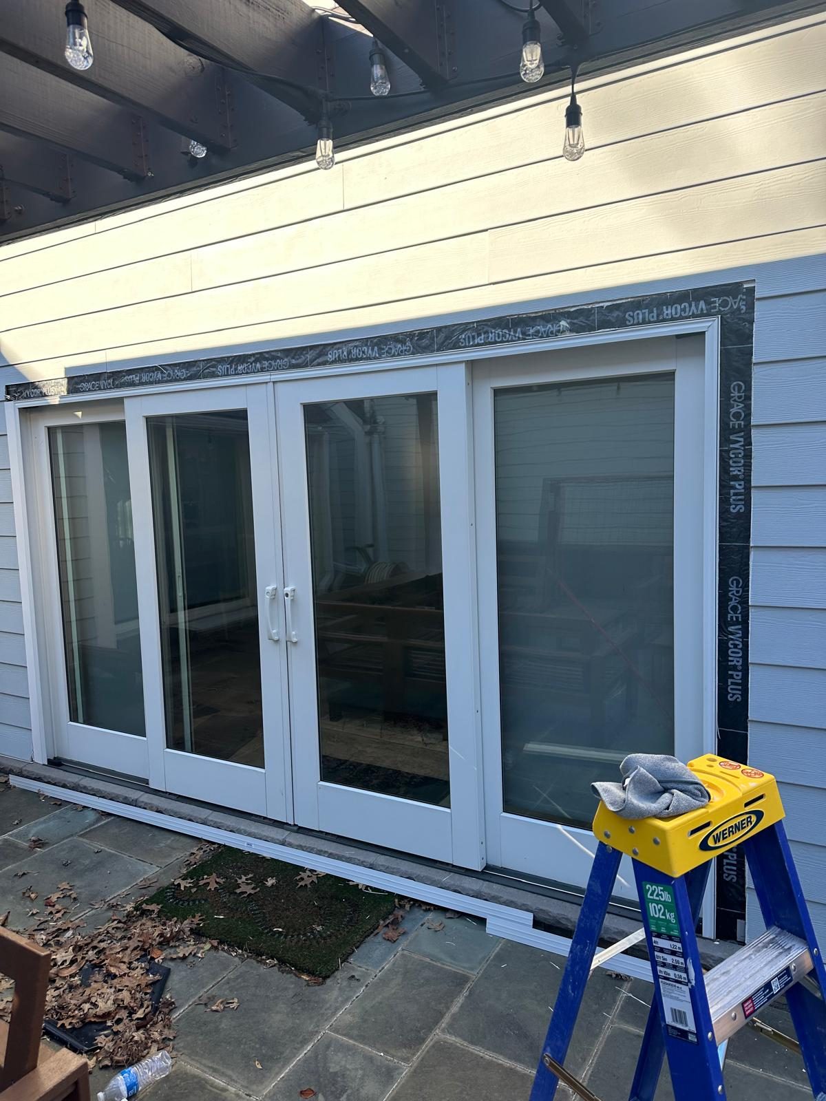 New patio door unit set in the opening with flashing membrane taped around the head and jambs