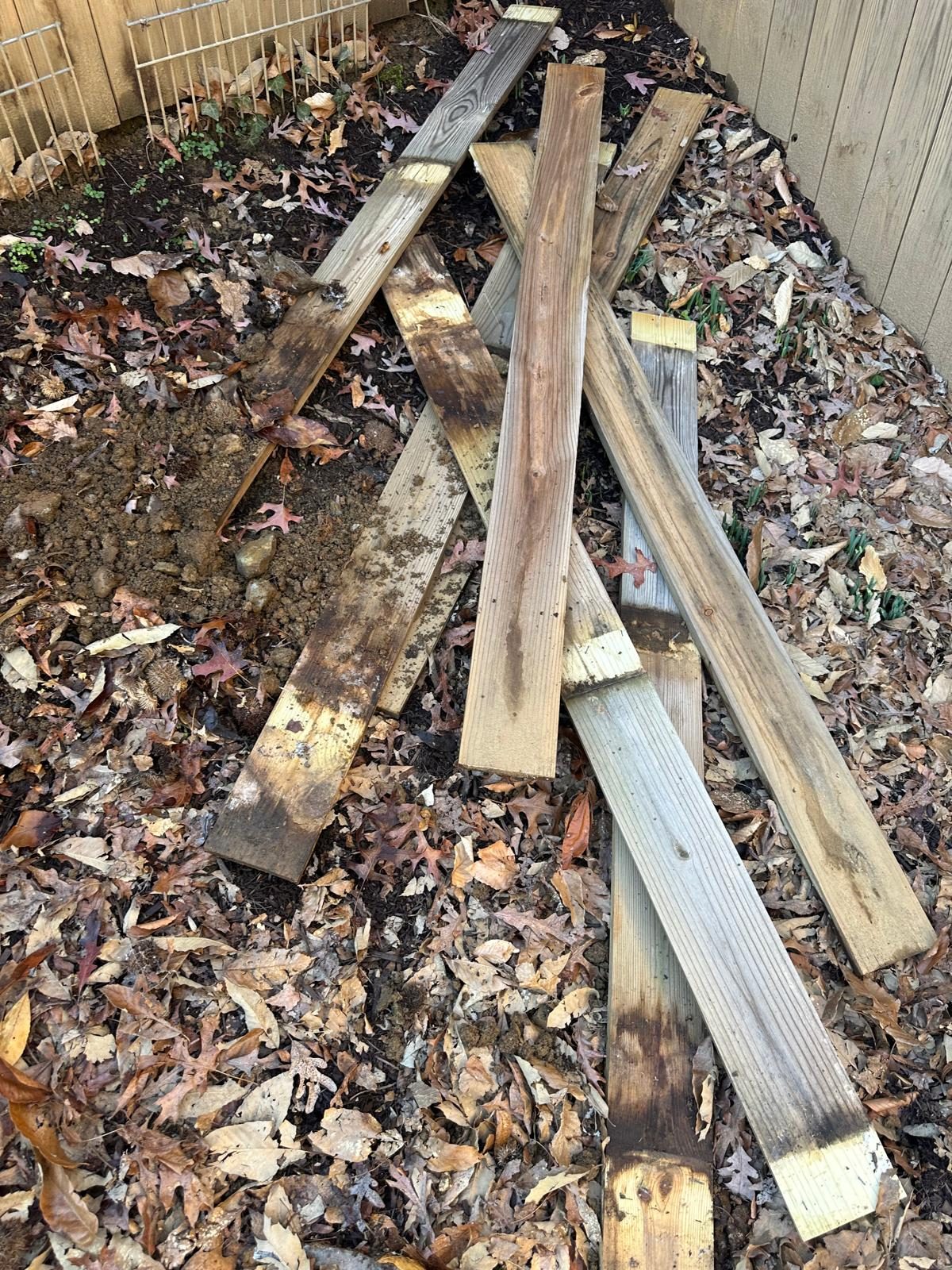Rotted fence post base with rails removed, showing decay running into the ends of the boards