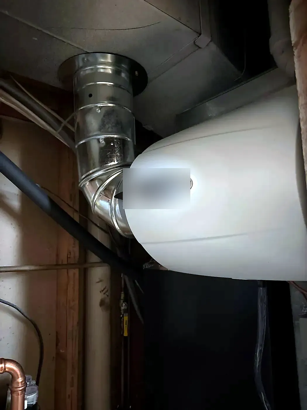 White humidifier housing mounted on dark ductwork with a round metal duct connection above it