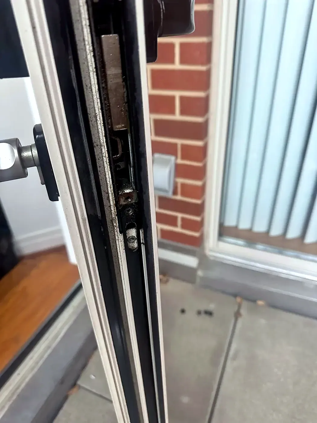 Close-up of a multipoint lock mechanism on the edge of a sliding door panel