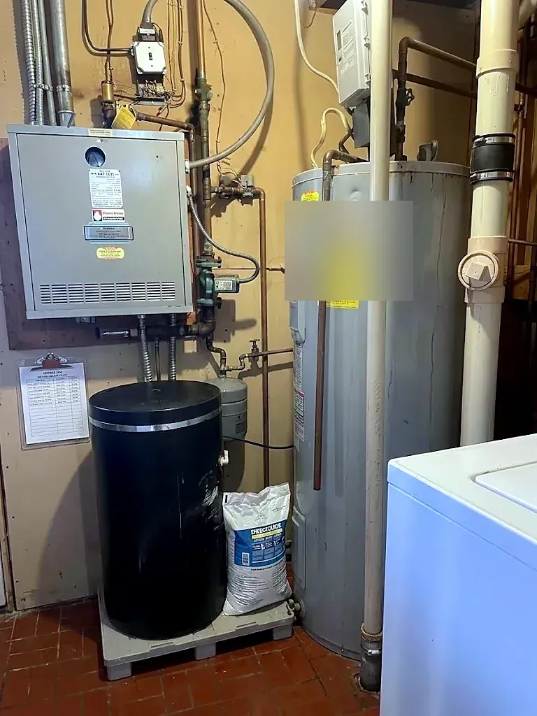 Utility room with a tank water heater, wall-hung furnace, black expansion tank and a white washer on tile floor