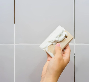 professional bathroom regrout in mclean va featuring a technician applying fresh grout to restore tile walls.