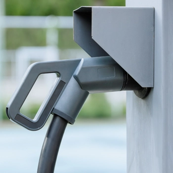 close-up of a grey electric vehicle charging connector mounted securely in its holster, showcasing the work of professional ev charger installers in oakton va.