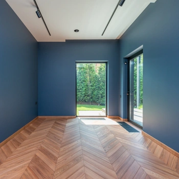 freshly painted blue room with large windows and modern wood flooring showcasing professional painting results.