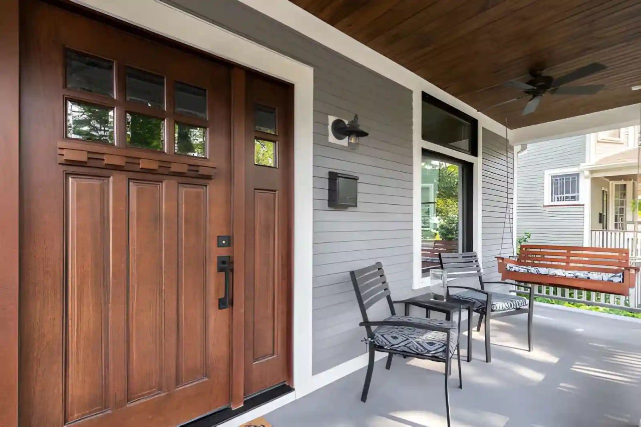 wooden front entry door on a residential porch, representing professional front door repair and maintenance service.