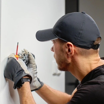 a professional electrician wearing protective gloves uses a specialized screwdriver to perform a precise gfci outlet installation in herndon va.