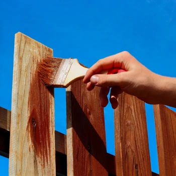 residential fence repair in herndon va with contractor restoring and staining wooden fence boards