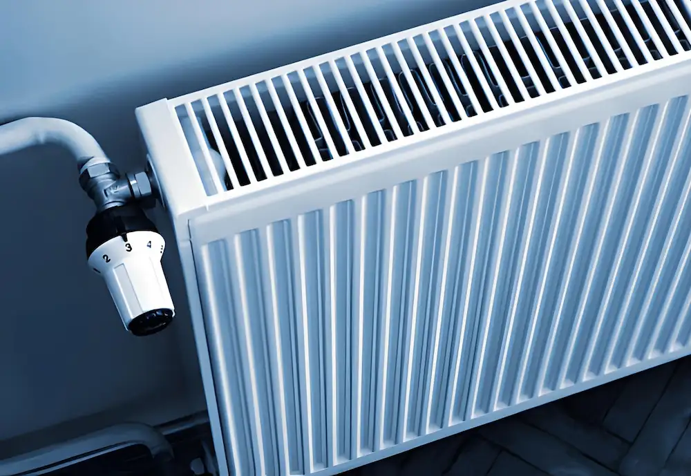 white wall-mounted radiator with a thermostat valve attached for controlling home heating. local heating repair in falls church va