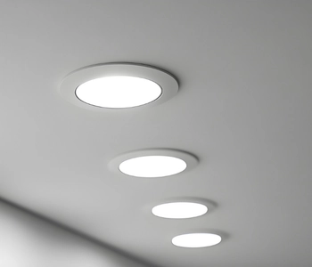 a row of four circular led recessed lights glowing on a white ceiling, highlighting the results of professional recessed lighting replacement services in burke va.