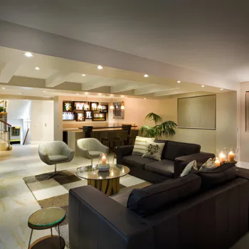 professional basement remodeling in alexandria, va, showcasing a finished luxury basement with a modern living area, recessed lighting, a sleek home bar, and contemporary furniture.