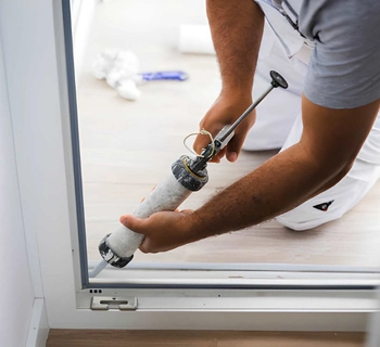 sliding door repair in herndon va with technician sealing residential patio sliding door frame