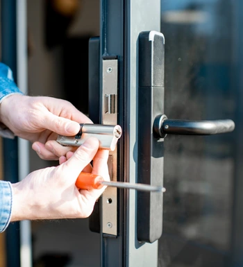 storm door replacement in oakton va with technician installing new handle and lock on residential glass storm door