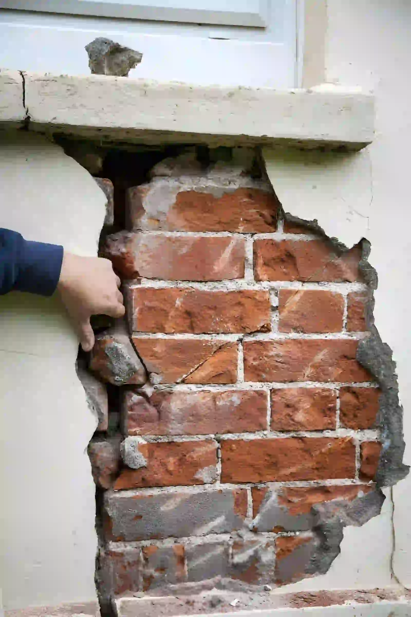 foundation inspection and repair in fairfax va showing damaged exterior wall with exposed brick and structural cracks