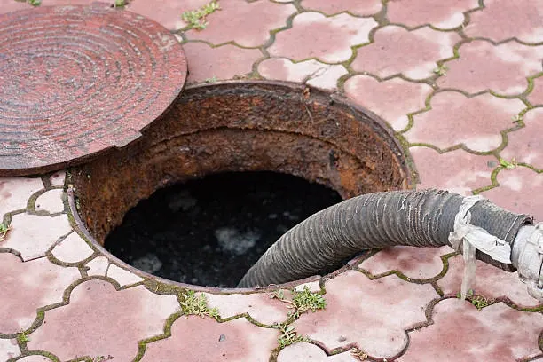 sewer line snaking in fairfax va hose inserted into an open sewer manhole during sewer line snaking and cleaning service.