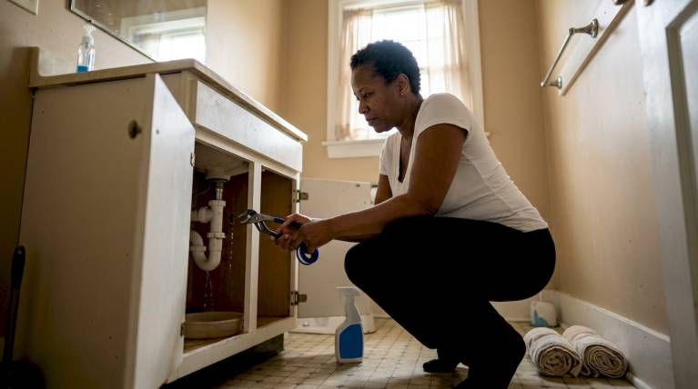 plumbing repair mistakes alexandria homeowners must avoid 7 homeowner checking leaking kitchen sink pipes
