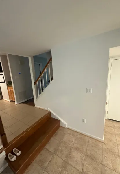 home additions in merrifield va 3 main hallway staircase connection and multi-level entryway built by a premier home addition company in merrifield, va, showing custom stained wood steps and a classic white and oak banister rail system.